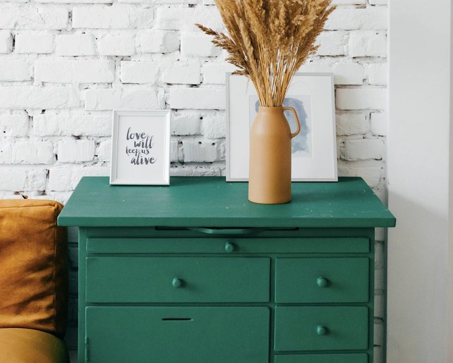Vase with wheat, two picture frames on a green table